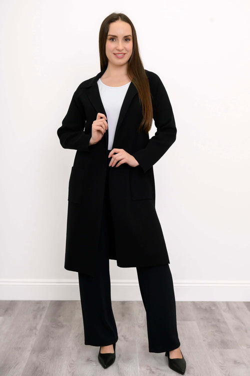Front view of model wearing black open front cotton knit jacket with pockets
