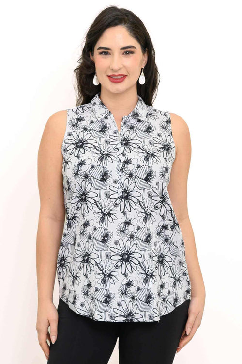 Woman wearing a sleeveless white tank top with black floral print and quarter-zip detail