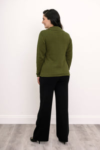 Back view of a woman wearing a hip length green cotton sweater highlighting the clean tailoring and shoulder fit.