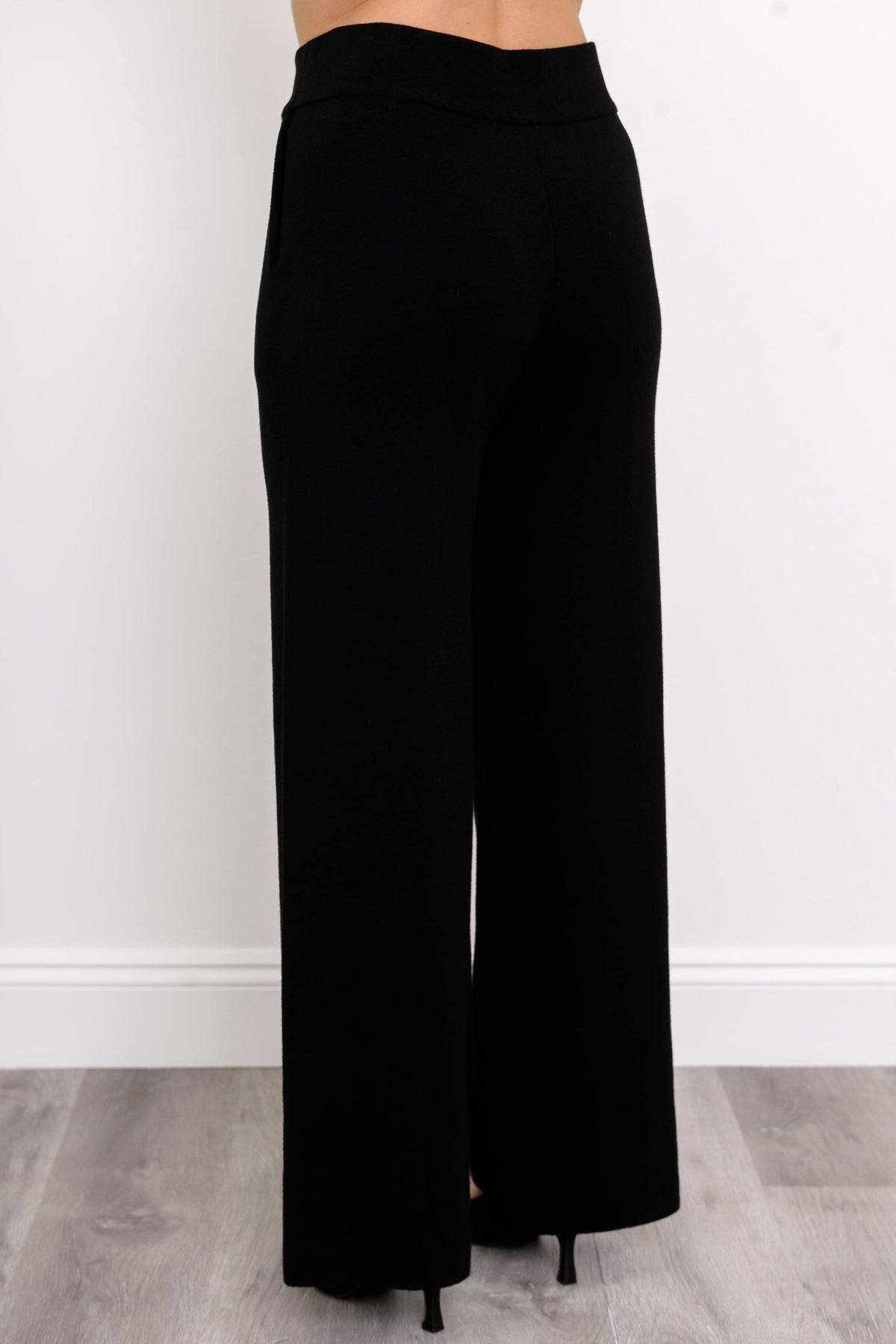 Rear view of onyx casual trousers, highlighting a comfortable flat waistband and pocket-free back panel design.