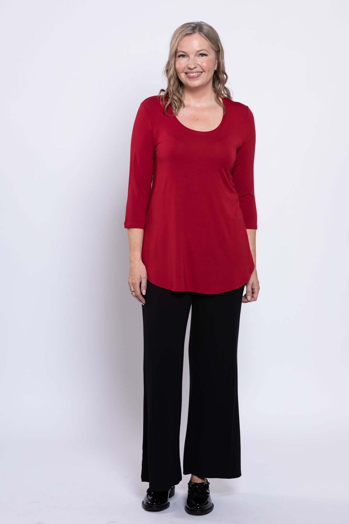 Front angled view of woman in red bamboo 3/4 sleeve top with black pants