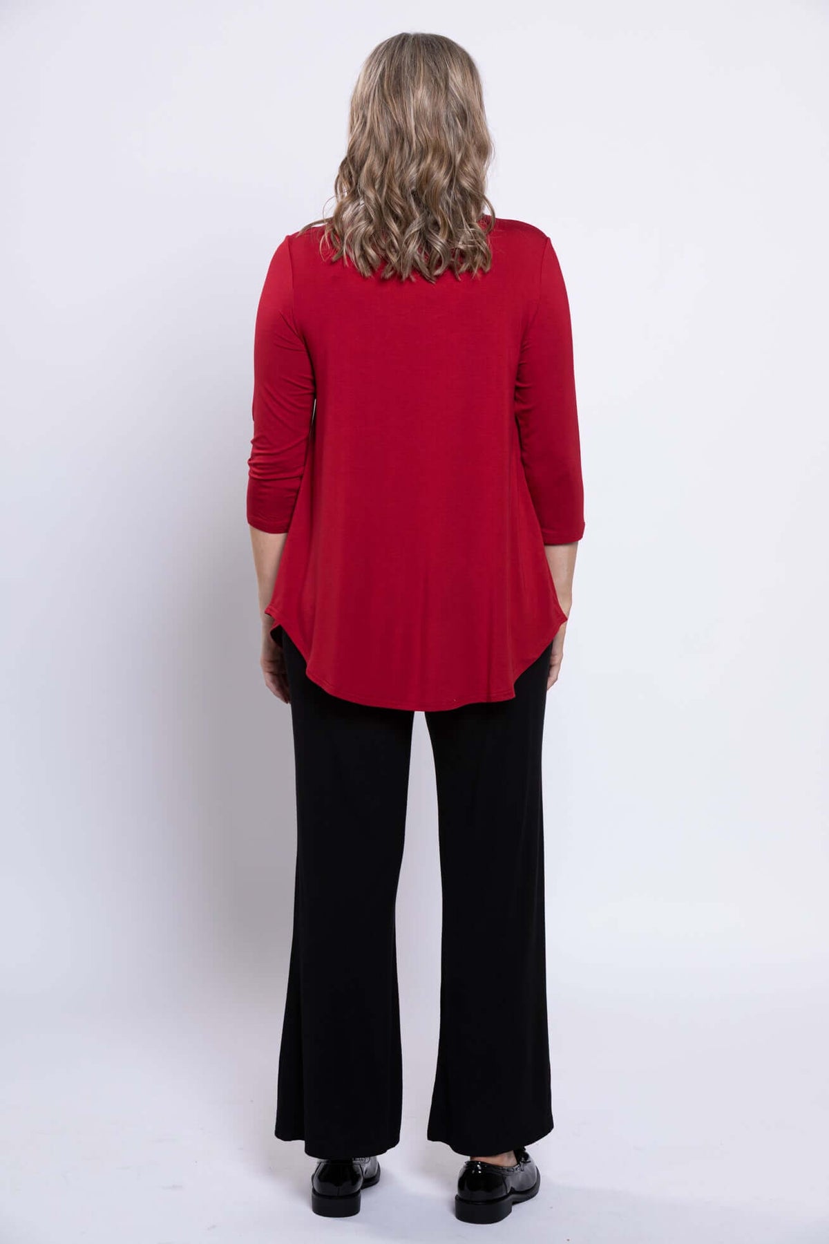 Back view of woman wearing red 3/4 sleeve bamboo top and black pants