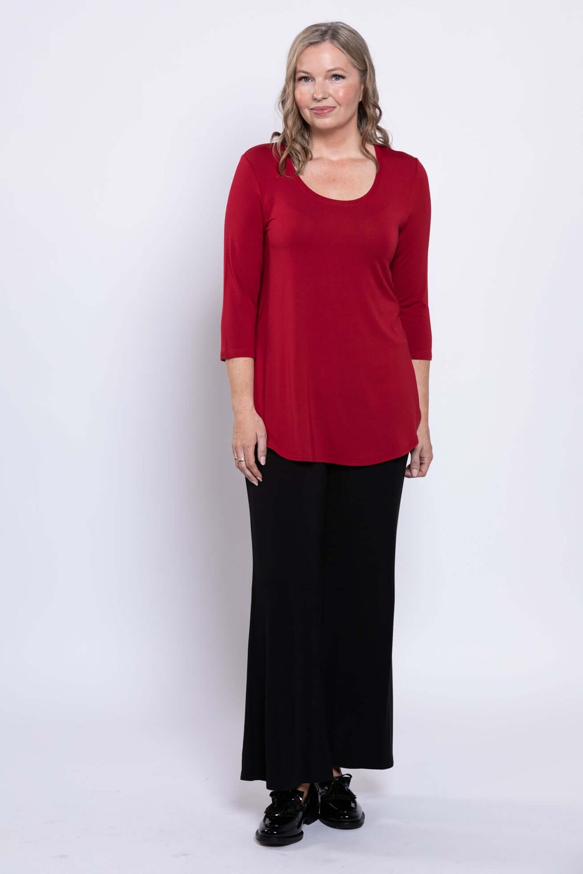 Full body front view of woman in red 3/4 sleeve bamboo top and black pants