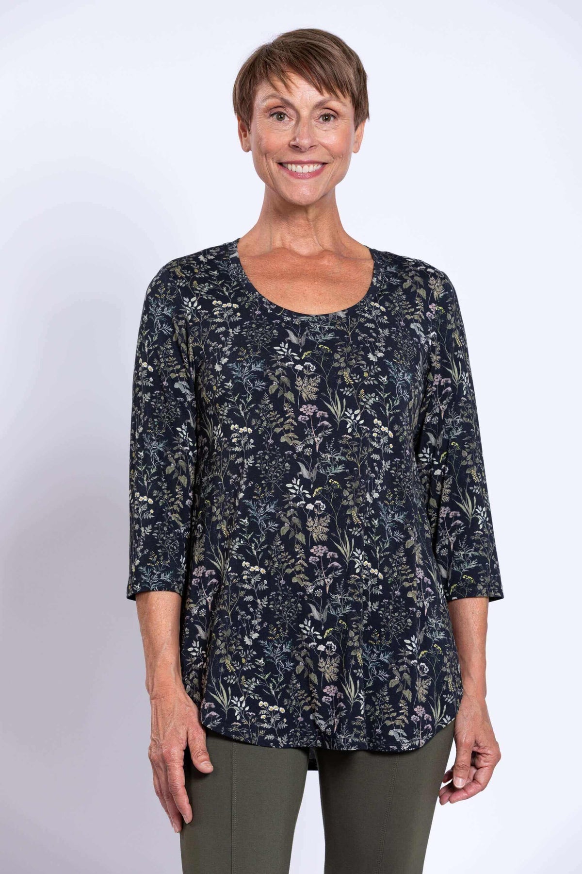 Front view of a woman wearing a black floral 3/4 sleeve bamboo top