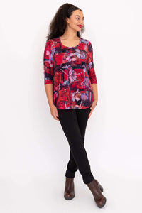 Model looking sideways in red floral print top with black pants and brown boots