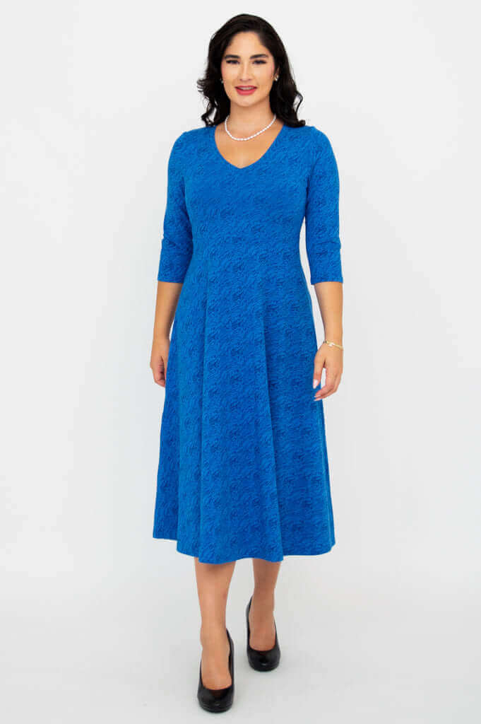 Woman modeling a royal blue midi dress with 3/4 sleeves and flared skirt, front view