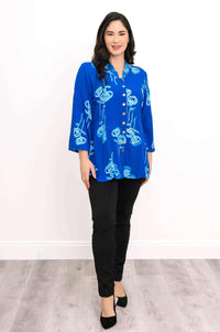 Front view of woman in blue floral blouse and black pants