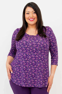 Woman modeling a violet floral 3/4 sleeve top, front view