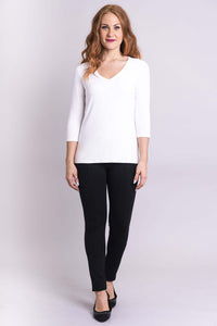 Full-body view of woman in white V-neck 3/4 sleeve bamboo top and black pants