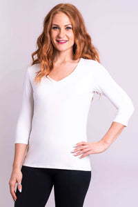 Woman wearing white V-neck 3/4 sleeve bamboo top, hand on hip