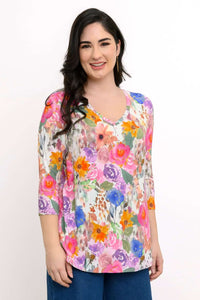 Woman wearing a vibrant floral V-neck 3/4 sleeve bamboo top, smiling
