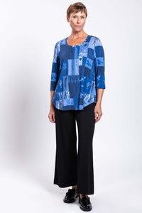 Model standing in blue patchwork Jazz 3/4 sleeve bamboo top and black trousers