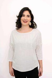 Close-up of woman wearing a white pinstripe top with 3/4 sleeves and gold leaf earrings