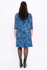 Back view of a blue bamboo dress with 3/4 sleeves and a floral pattern on a woman