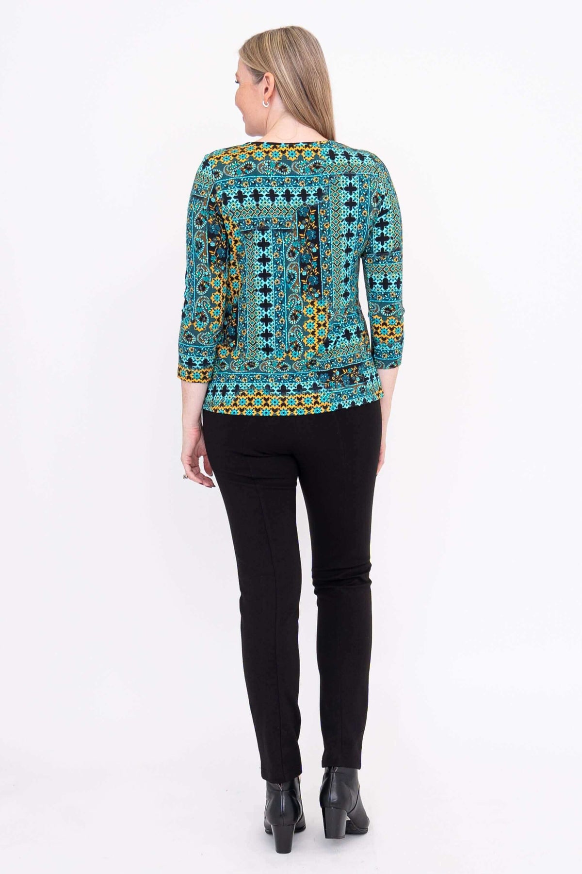 Back view of woman wearing blue and yellow patterned 3/4 sleeve tee with black pants