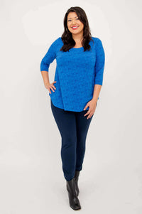 Woman in sapphire blue 3/4 sleeve top and navy pants, standing full-body, front view