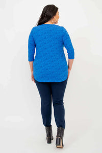 Back view of woman in sapphire blue textured 3/4 sleeve top and navy pants