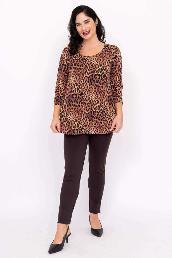 Front view of woman posing in a leopard print 3/4 sleeve top with brown pants