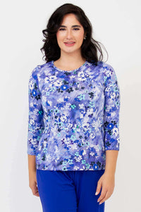 Woman wearing a fitted 3/4 sleeve tee with vibrant blue watercolor floral print