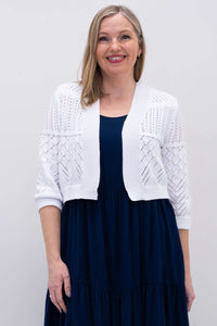 Front view of woman wearing a white cropped knit sweater with 3/4 sleeves