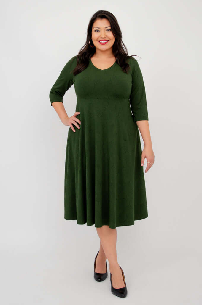 Woman wearing a forest green midi dress with V-neck and three-quarter sleeves, front view