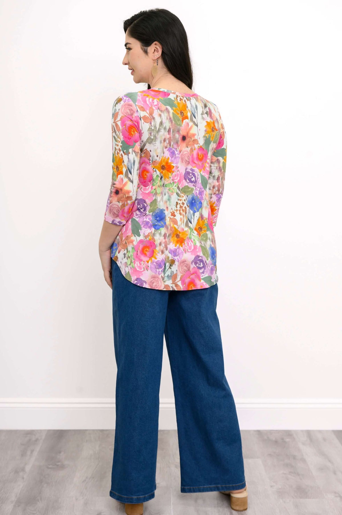 Back view of woman wearing a floral V-neck bamboo top with 3/4 sleeves