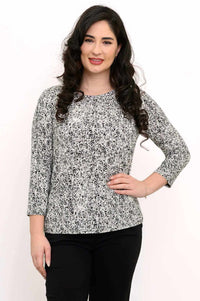 Woman wearing a fitted black and white rose print tee with 3/4 sleeves