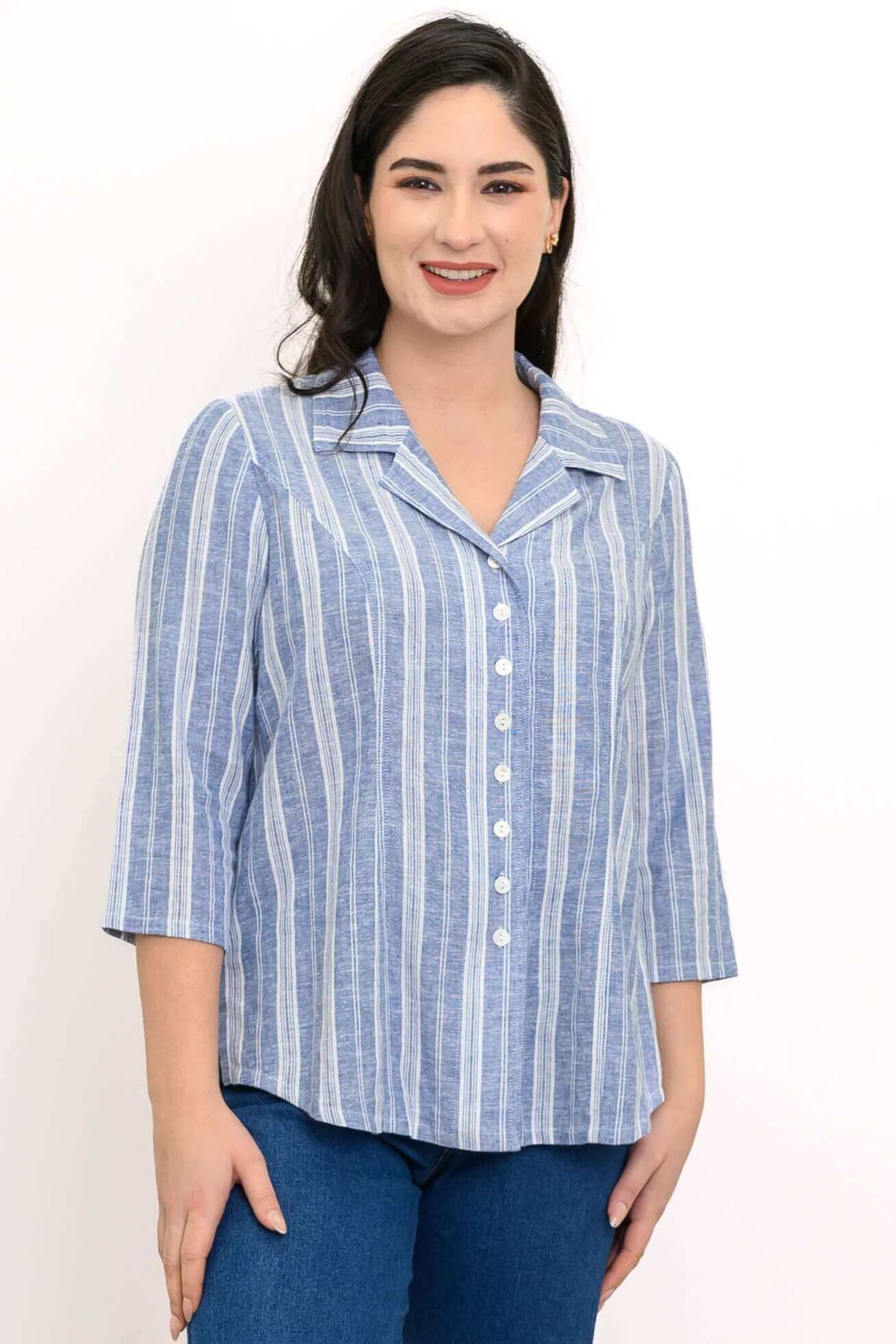 Woman wearing a blue and white striped button-up shirt with 3/4 sleeves, smiling at the camera