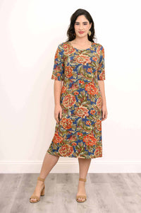 Woman modeling a blue and orange floral dress with 3/4 sleeves, standing straight