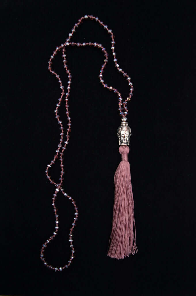 Amethyst beaded necklace with Buddha pendant and mauve tassel on black background