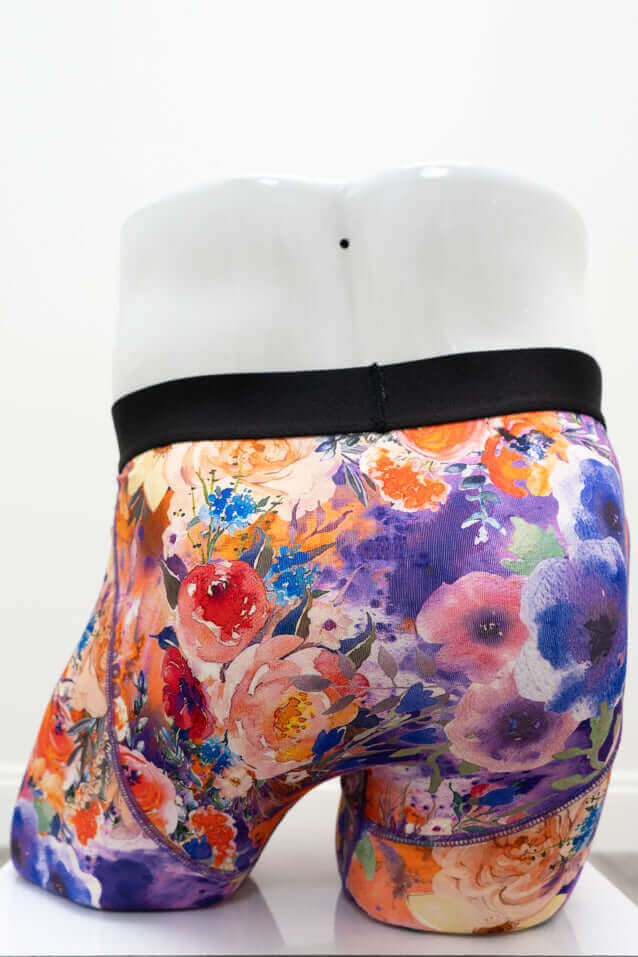 Angled back view of men's bamboo boxer briefs with vivid floral design and black waistband