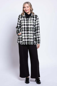 Slight angled front view of woman modeling a black and white houndstooth coat