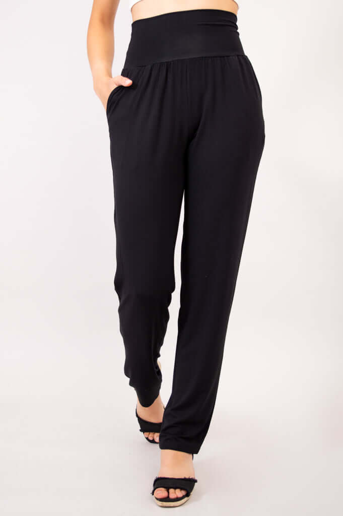 Angled front view of Clair black bamboo pants with hands in deep hidden pockets