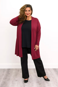 Front view of a plus size female model wearing a red French Terry open jacket  with a red top and black pants with black heels against a white backdrop and grey floor