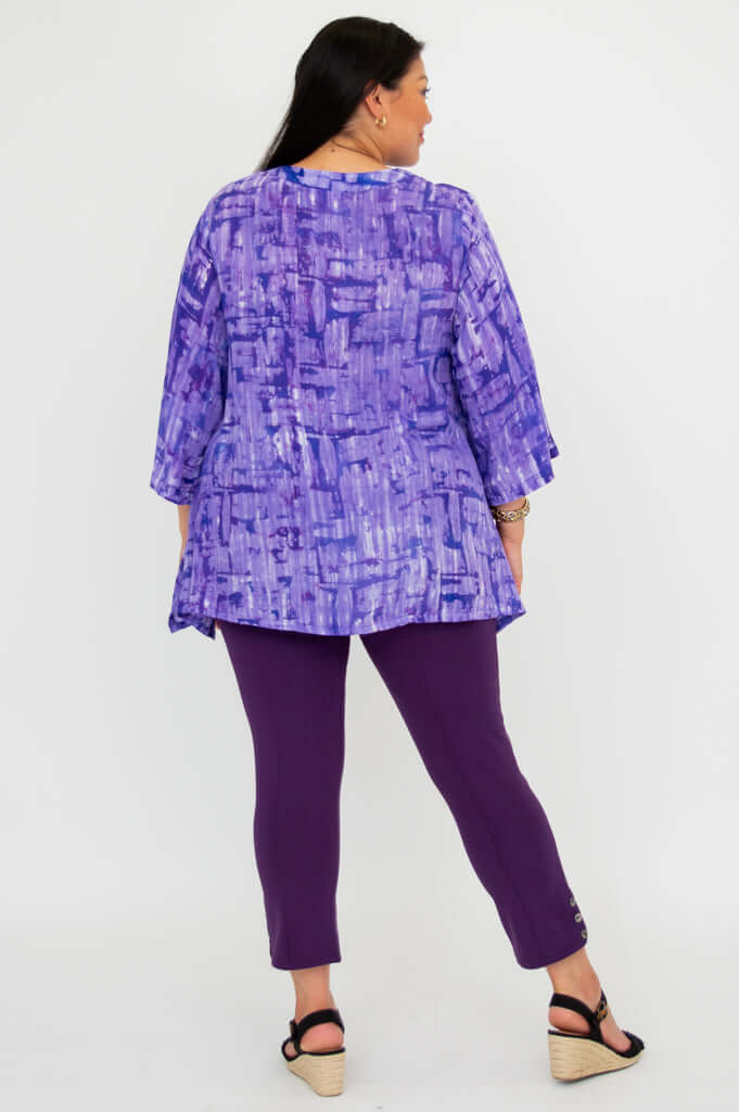 Back view of model showing full length and pattern of purple tunic top