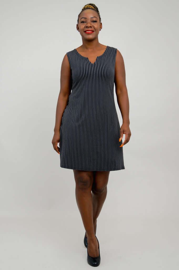 Back view of woman wearing a black and white pinstripe sleeveless shift dress