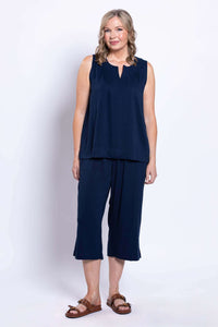 Back view of a woman wearing navy linen capri pants and sleeveless top