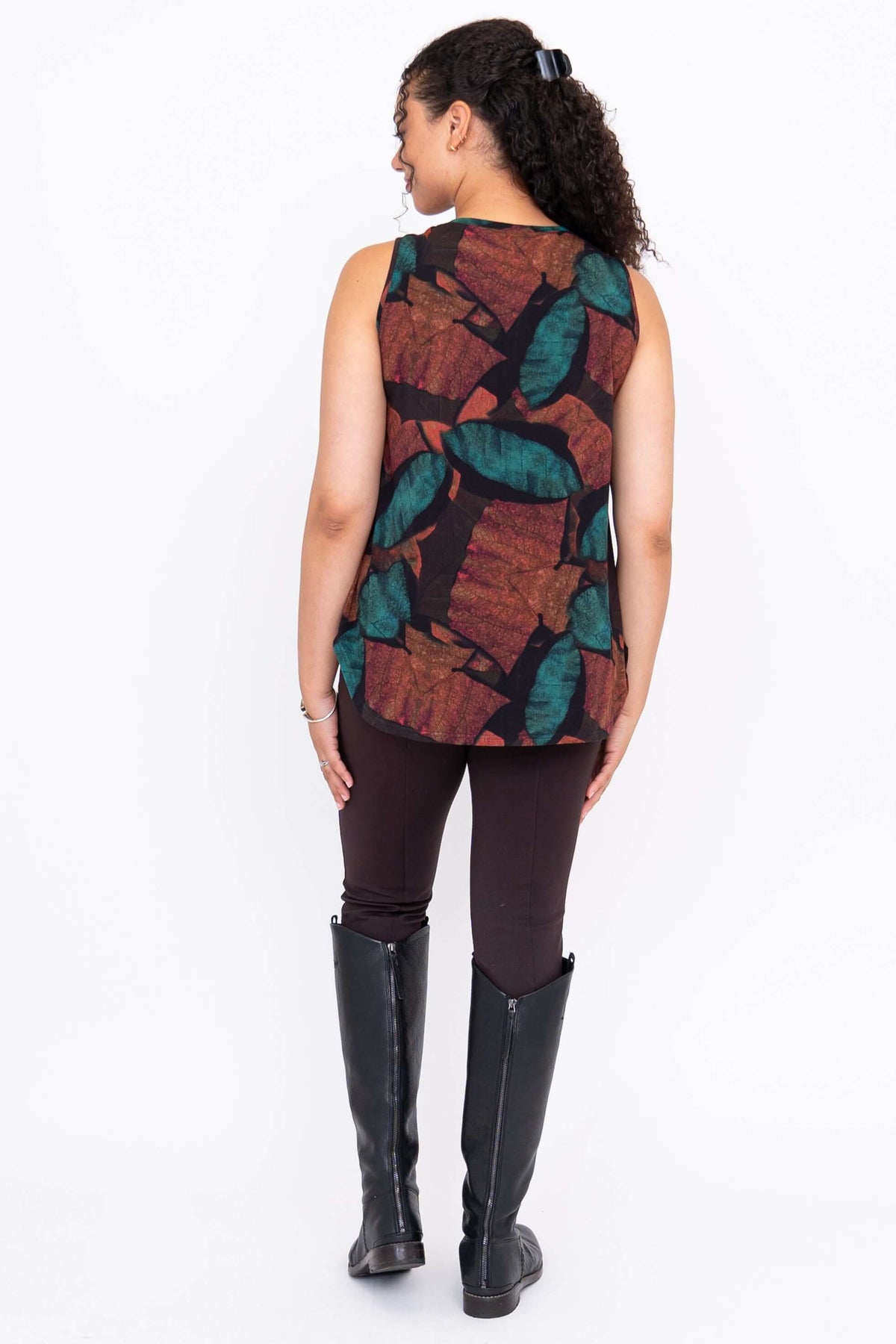 Ful body back view of model wearing sleeveless autumn print tank and brown pants