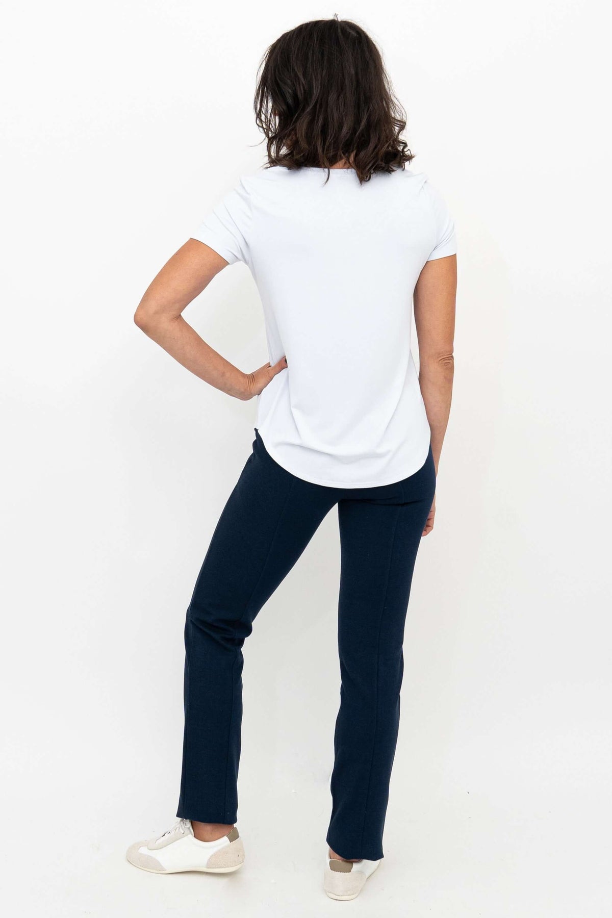 Back view of woman in navy Nadia Pants and white t-shirt