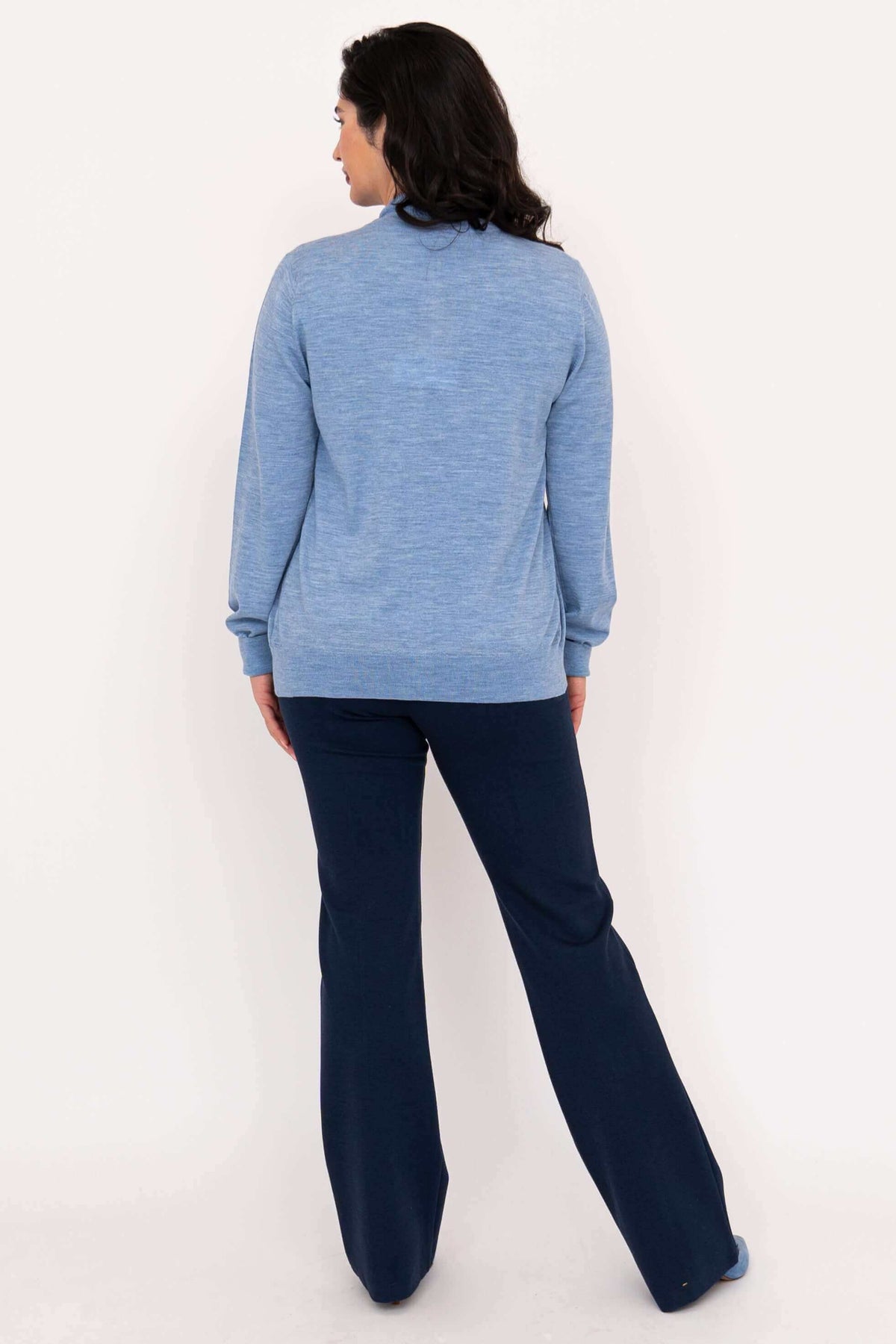 Back view of woman in light blue crew neck cardigan and navy pants