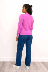Back view of woman in pink button-up cardigan and blue jeans