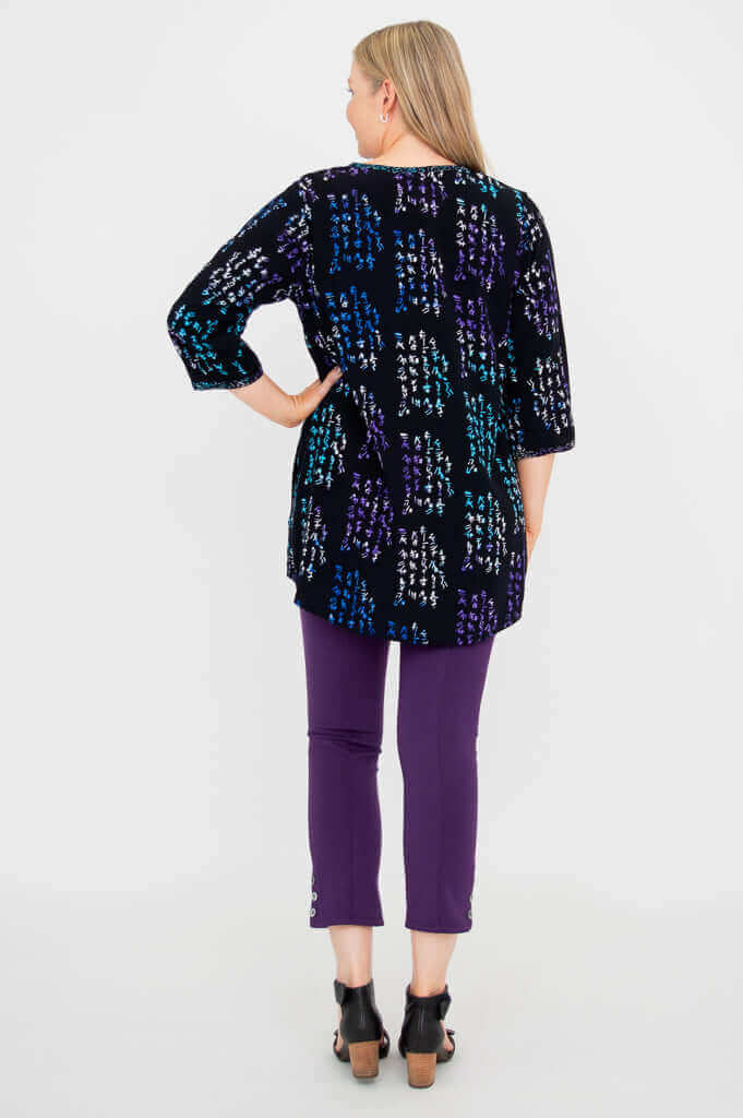 Back view of woman wearing black batik blouse with colorful patterns