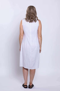 Back view of woman in sleeveless white dress with vertical stripes
