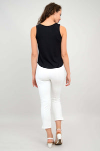 Back view of woman wearing a sleeveless black tank top and white pants