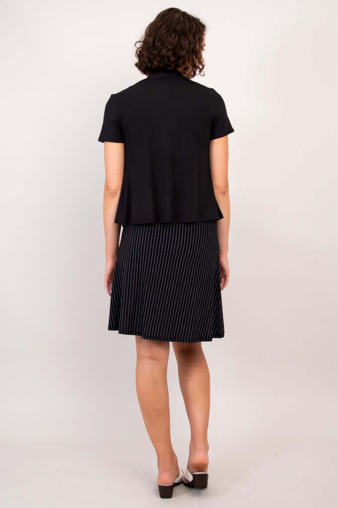 Back view of woman in black short sleeve open jacket and pinstripe skirt