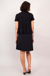 Back view of woman in black short sleeve open jacket and pinstripe skirt