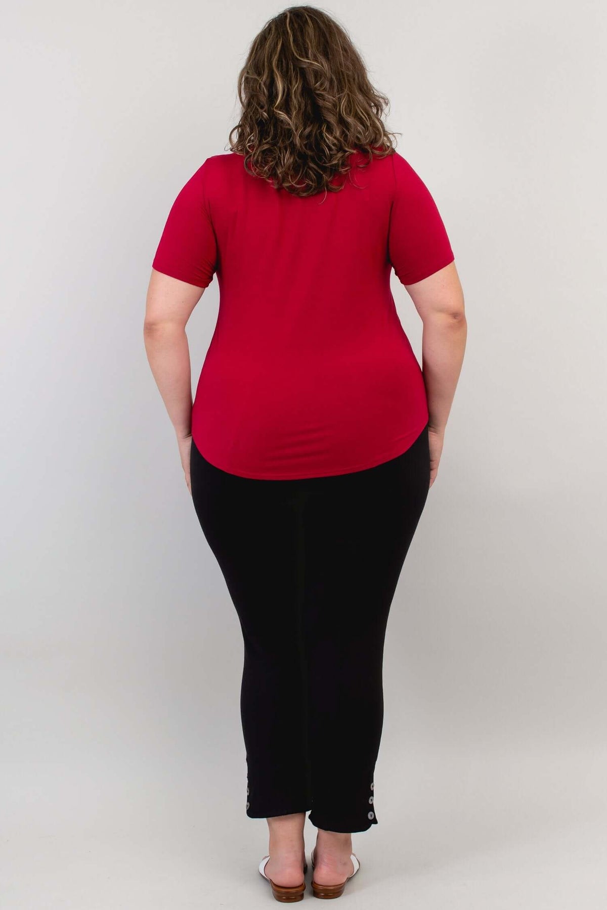 Back view of woman in a crimson scoop neck short sleeve tee and black pants