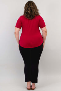 Back view of woman in a crimson scoop neck short sleeve tee and black pants