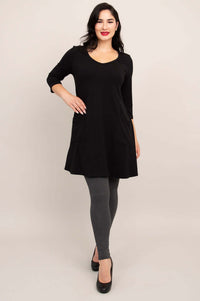 Model wearing black A-line tunic dress, shown from the back