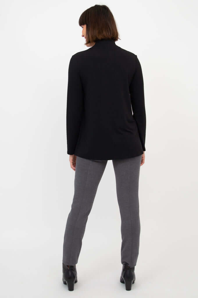 Back view of a woman wearing a black long sleeve top and grey pants